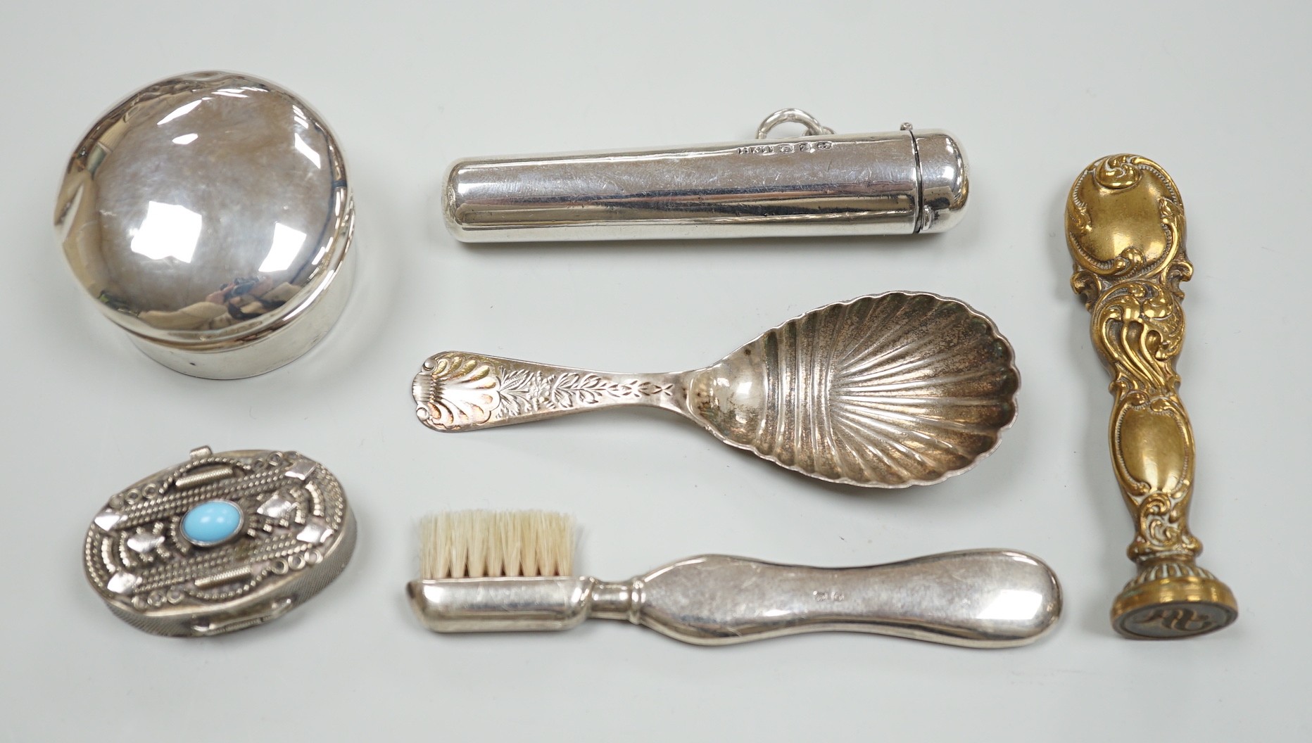 A late Victorian silver caddy spoon, 92mm, a silver cigarette holder, toothbrush, two trinket boxes and a brass seal.